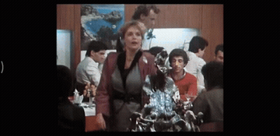Woman Standing Before Dragon Statue In Crowded Room GIF