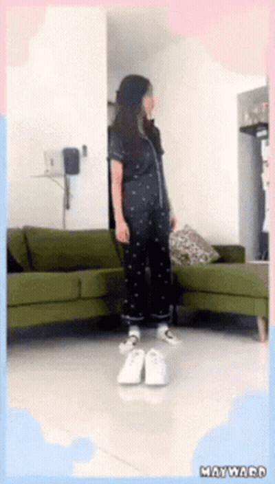 Woman Standing By Green Couch In Living Room GIF