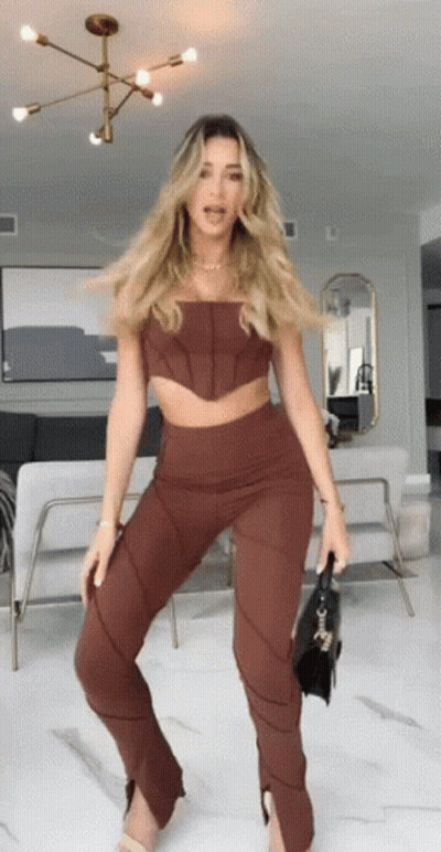 Woman Standing In Brown Top And Pants GIF