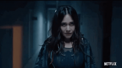 Woman Standing In Dark Hallway With Netflix Logo GIF