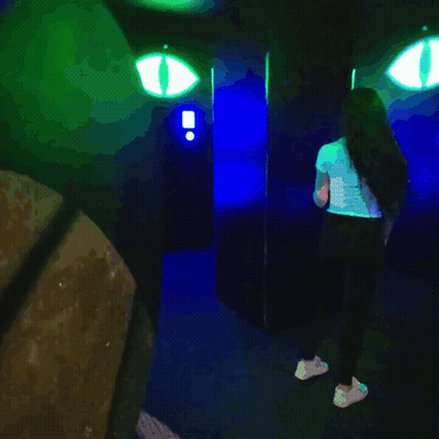 Woman Standing In Dark Room With Glowing Eyes GIF