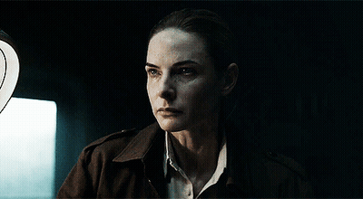 Woman Standing In Dark Room With Light Behind Her GIF