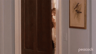 Woman Standing In Doorway With Peacock GIF