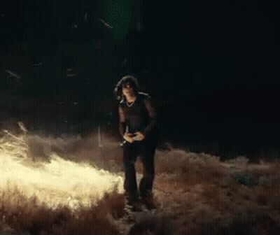 Woman Standing In Field At Night With Camera GIF