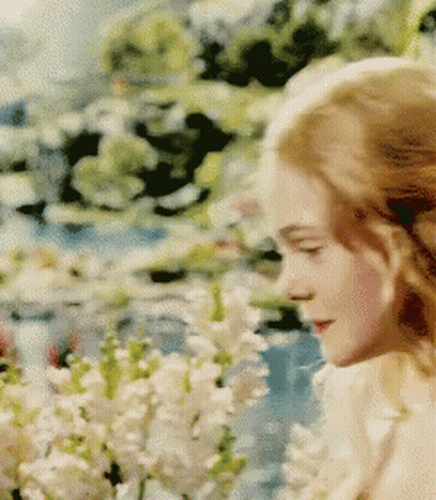 Woman Standing In Field Of Flowers GIF