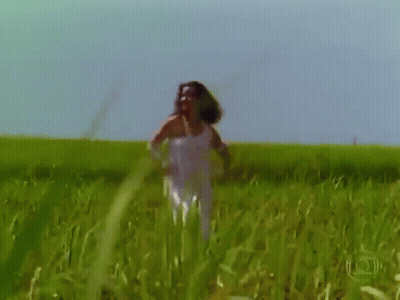 Woman Standing In Field Of Tall Grass GIF