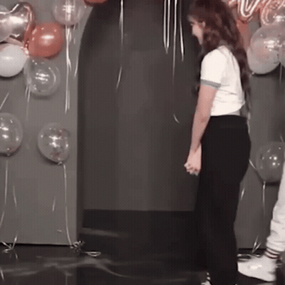 Woman Standing In Front Of Balloons Holding Hands GIF