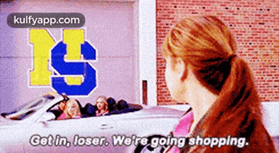 Woman Standing In Front Of Car Saying Get In Loser We're Going Shopping GIF
