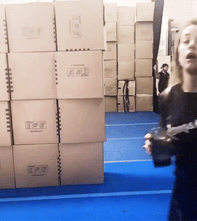 Woman Standing In Front Of Cardboard Boxes Saying T & P GIF