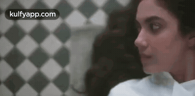 Woman Standing In Front Of Checkered Wall GIF