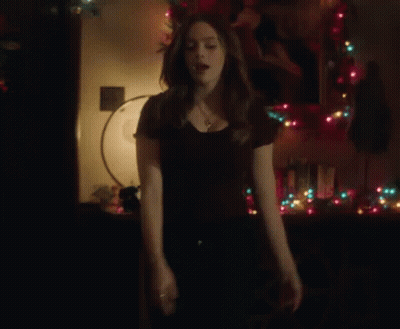 Woman Standing In Front Of Christmas Tree GIF