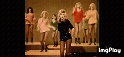 Woman Standing In Front Of Dancing Women GIF