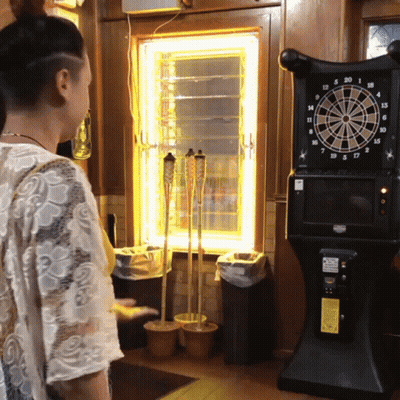 Woman Standing In Front Of Dart Board GIF