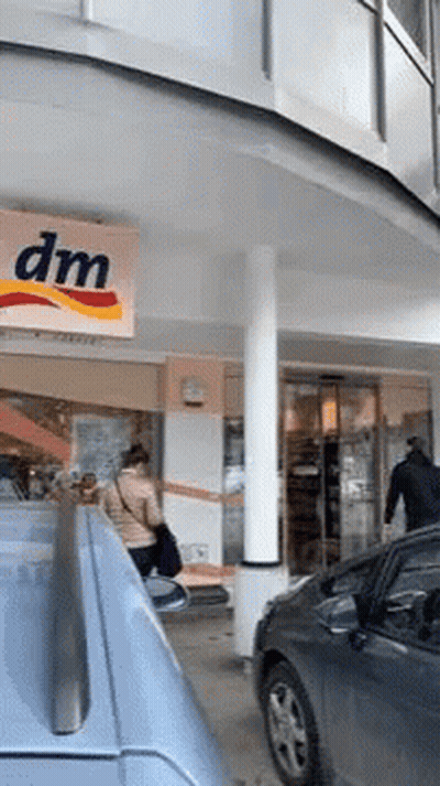 Woman Standing In Front Of DM Store GIF