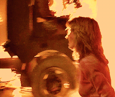 Woman Standing In Front Of Fire And Tire GIF