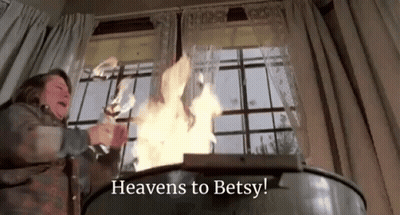 Woman Standing In Front Of Fire Saying Heavens To Betsy GIF