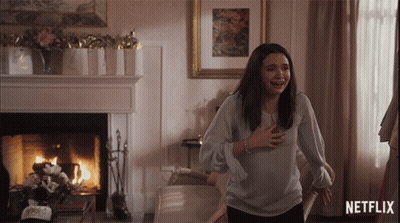 Woman Standing In Front Of Fireplace And Netflix Logo GIF
