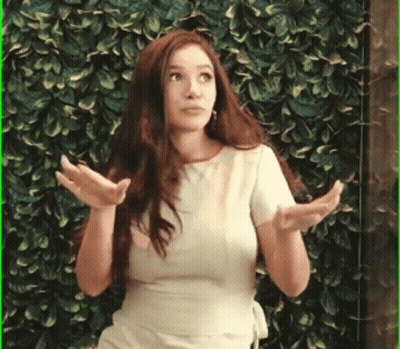 Woman Standing In Front Of Green Wall With Hands Out GIF