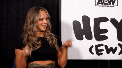 Woman Standing In Front Of Hey Crew Sign GIF