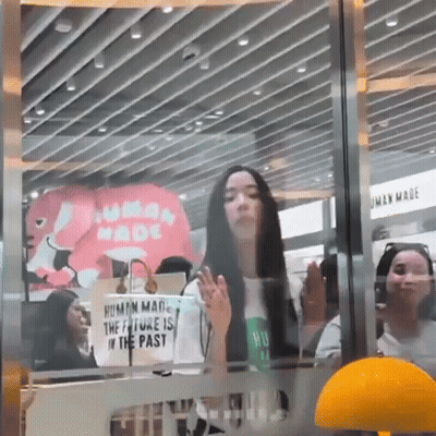 Woman Standing In Front Of Human Made Sign GIF