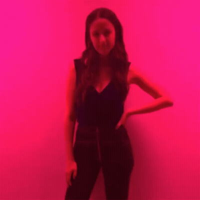 Woman Standing In Front Of Red Wall GIF