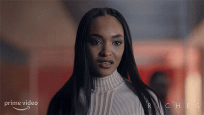 Woman Standing In Front Of Riches Sign GIF