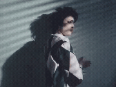 Woman Standing In Front Of Shadowed Wall GIF
