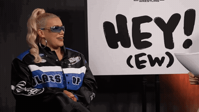 Woman Standing in Front of Sign Saying Hey