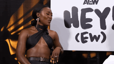 Woman Standing In Front Of Sign Saying Hey (Ew) GIF
