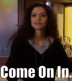 Woman Standing In Front Of Sign That Reads Come On In GIF