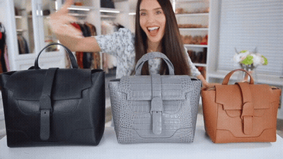 Woman Standing In Front Of Table With Three Bags GIF
