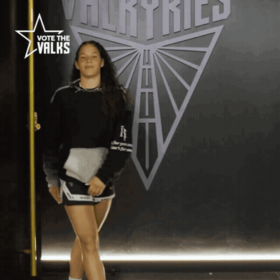 Woman Standing In Front Of Vote The Valks Sign GIF