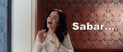 Woman Standing In Front Of Wall With Sabar Written Above GIF
