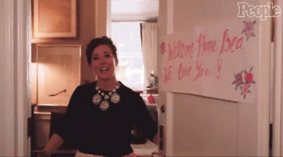 Woman Standing In Front Of We Love You Bea Sign GIF