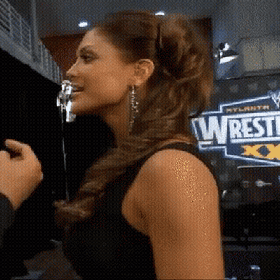 Woman Standing In Front Of Wrestle Sign GIF