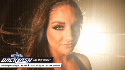 Woman Standing In Front Of WrestleMania Backlash Sign GIF