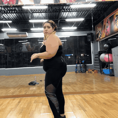 Woman Standing In Gym With J99 Sign GIF