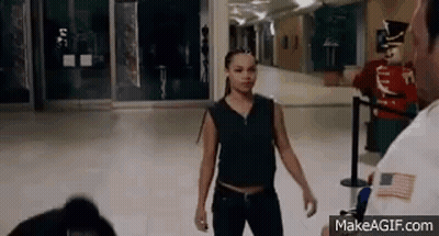 Woman Standing In Hallway With Security Guard GIF
