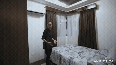Woman Standing Next To Bedroom Bed GIF