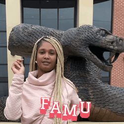 Woman Standing Next To Famu Snake Statue GIF