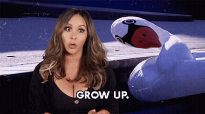 Woman Standing Next To Inflatable Flamingo Saying Grow Up GIF