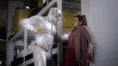Woman Standing Next To Man In Superhero Costume GIF