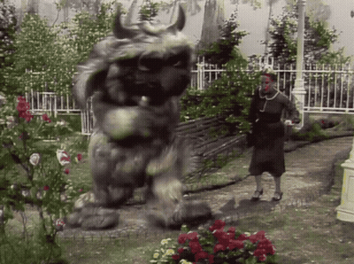Woman Standing Next To Monster Statue GIF