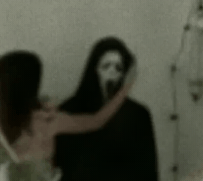 Woman Standing Next To Scary Ghost With Mask GIF