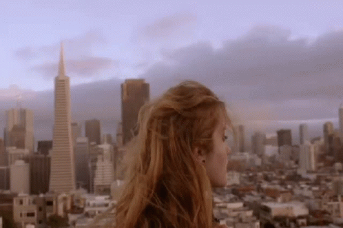 Woman Standing On Building Over City GIF