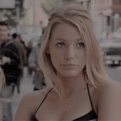 Woman Standing On City Street In Black Top GIF