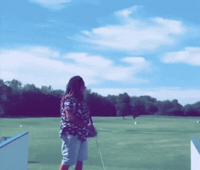 Woman Standing On Golf Course With Golf Club GIF