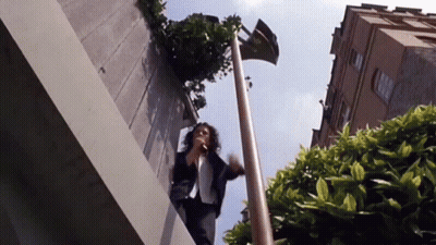 Woman Standing On Ledge Talking On Phone GIF