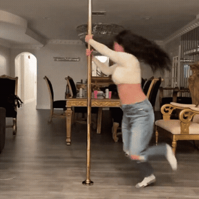 Woman Standing On Pole In Room GIF