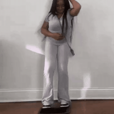Woman Standing On Skateboard In Room GIF